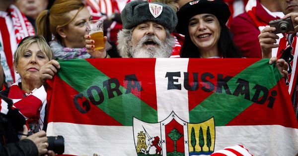Foto: Un aficionado del Athletic de Bilbao muestra una bandera vasca mientras anima a su equipo antes del inicio del partido. (EFE)