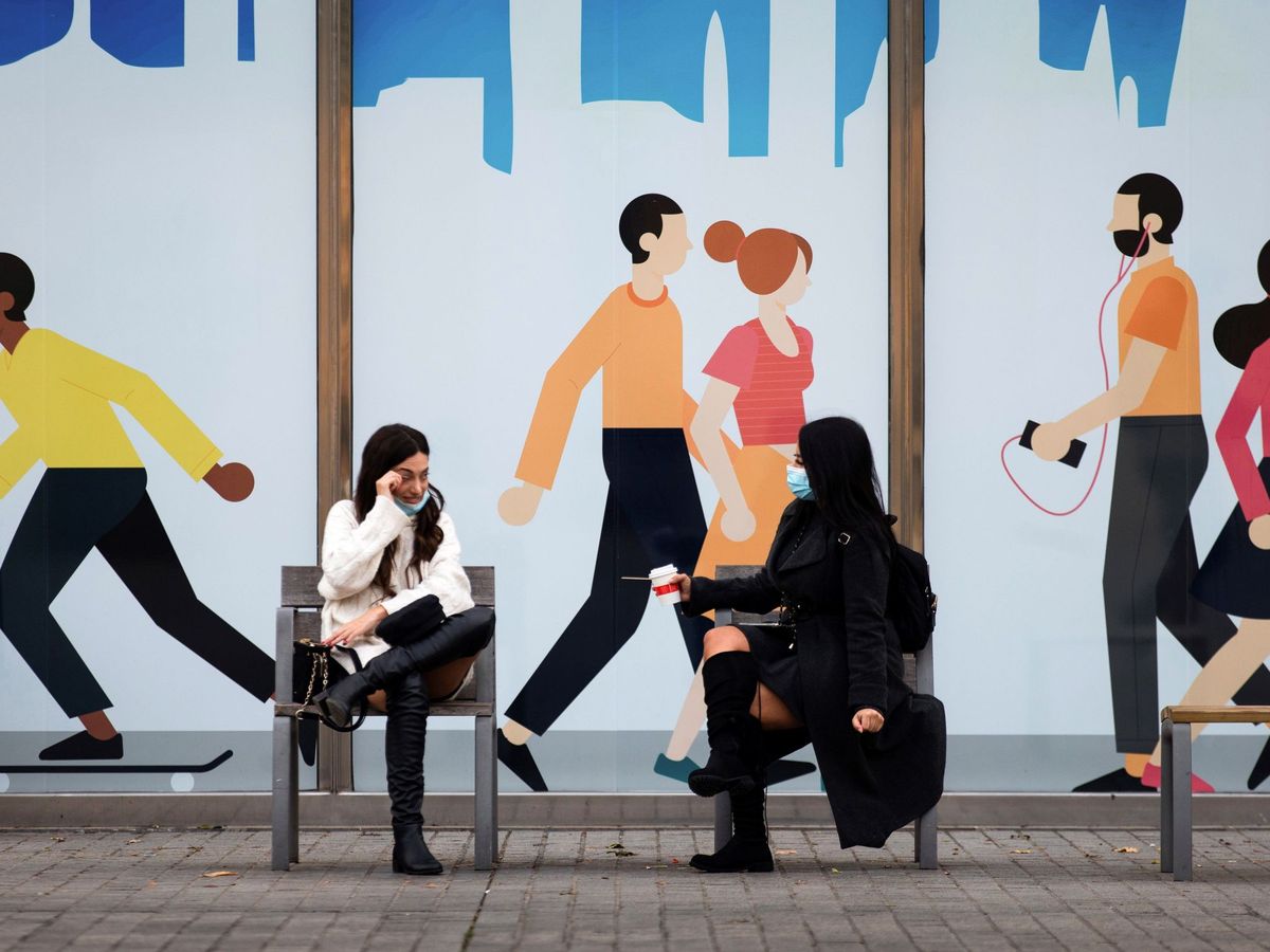 Foto: Dos mujeres conversan sentadas en un banco de las calles del barrio del Born de Barcelona. (EFE)