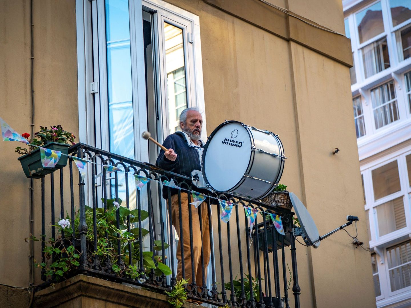 Un hombre toca un tambor desde su balcón en honor a los sanitarios. (EFE)