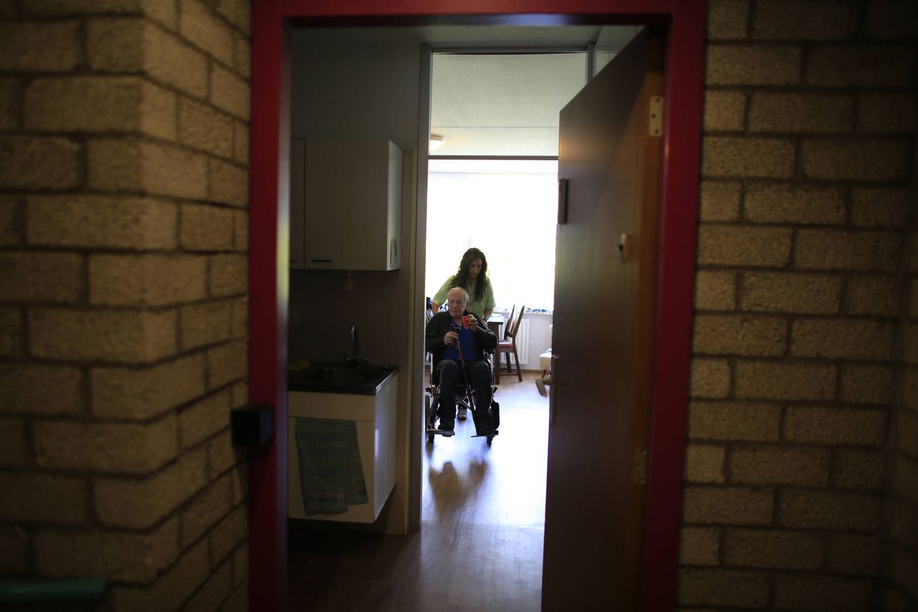 Una enfermera traslada a un paciente en silla de ruedas en un centro médico de La Haya (Reuters).