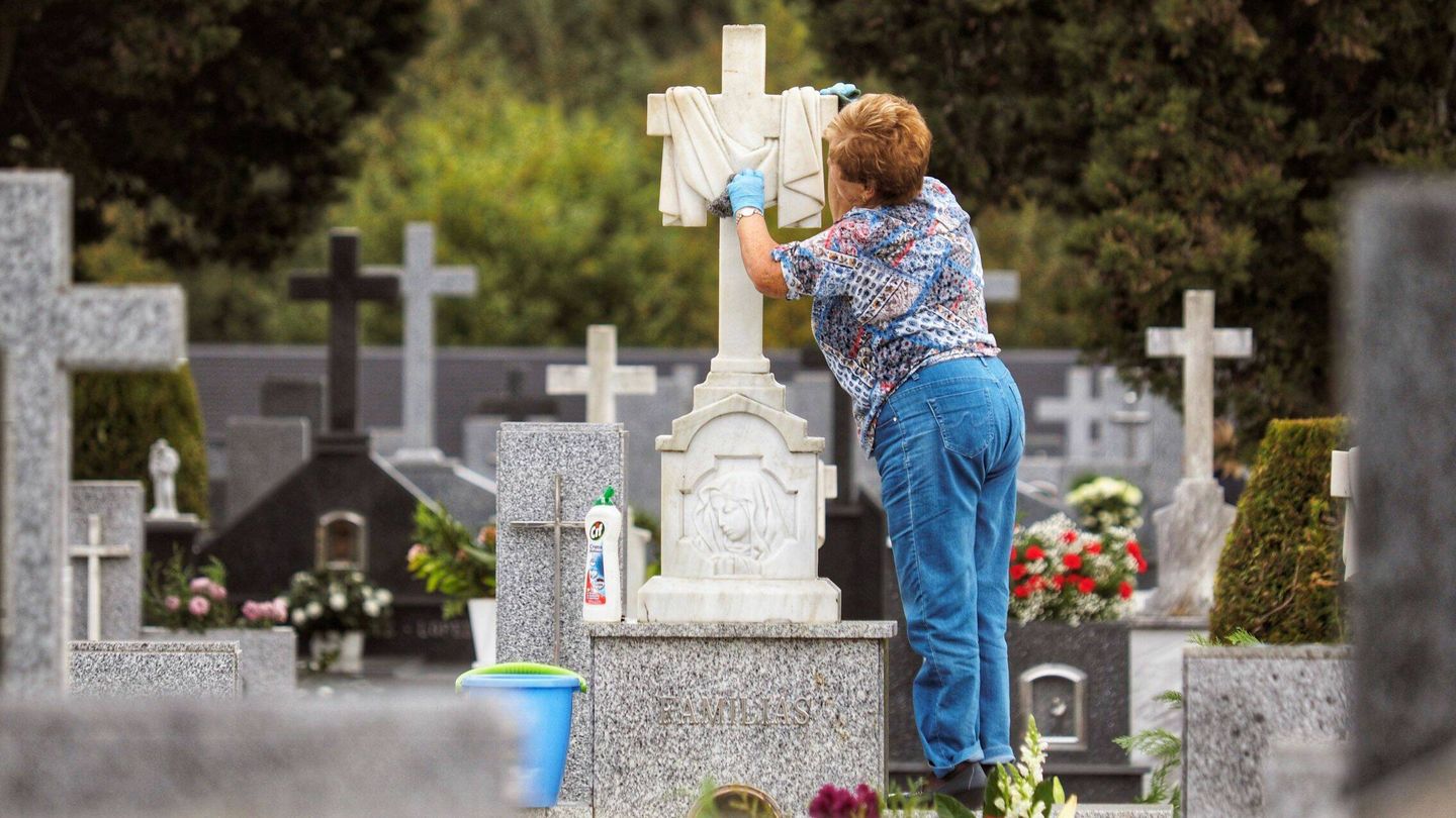 Una mujer limpia la tumba de un familiar. (EFE)