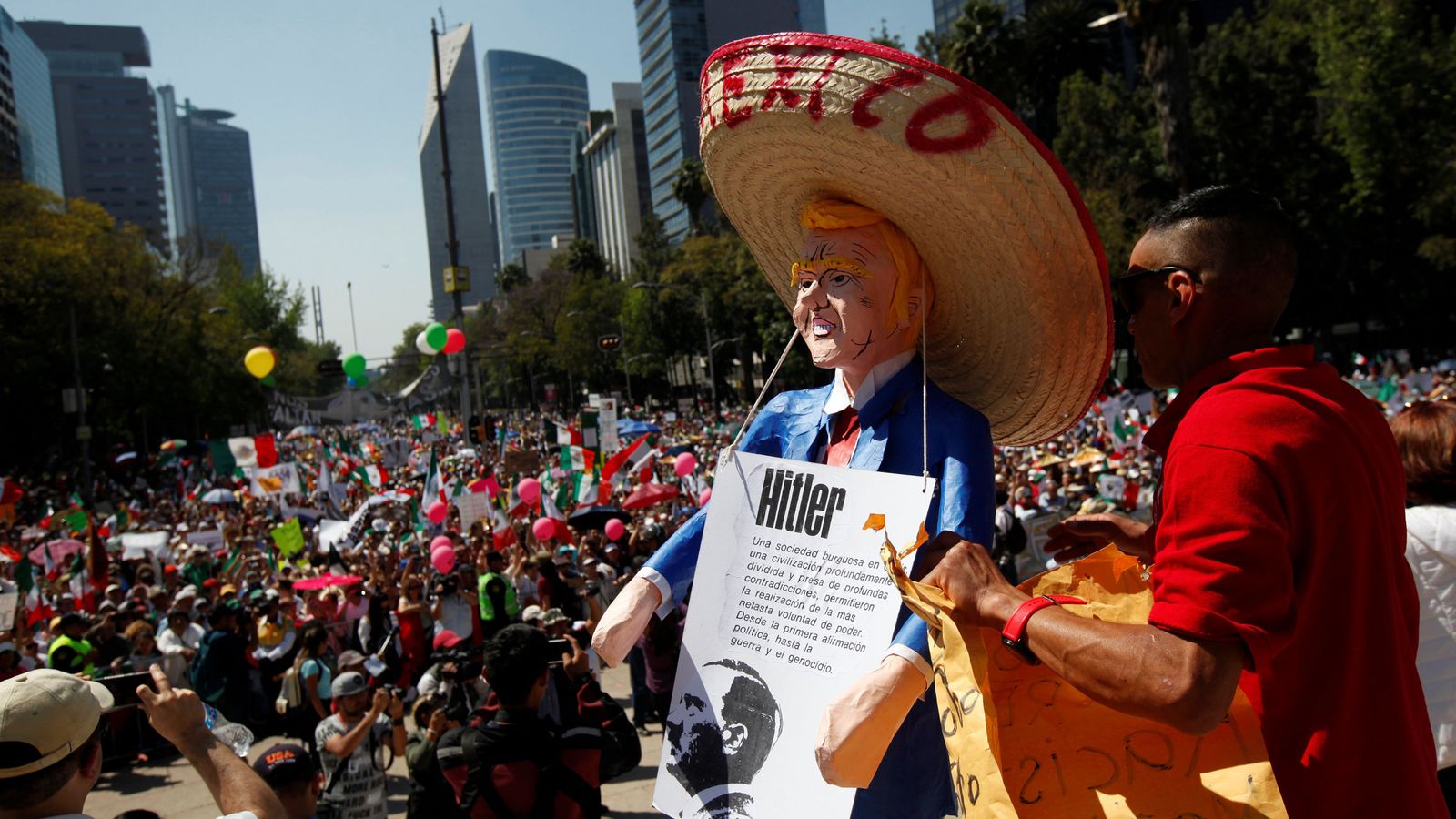 Foto: Un hombre sujeta un muñeco de Trump con un sombrero mexicano. (Reuters)