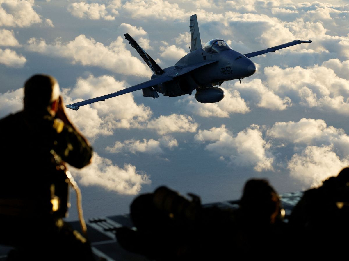 Foto: Un soldado toma fotos de un caza de la Fuerza Aérea española en 2023. (Reuters/Borja Suárez)