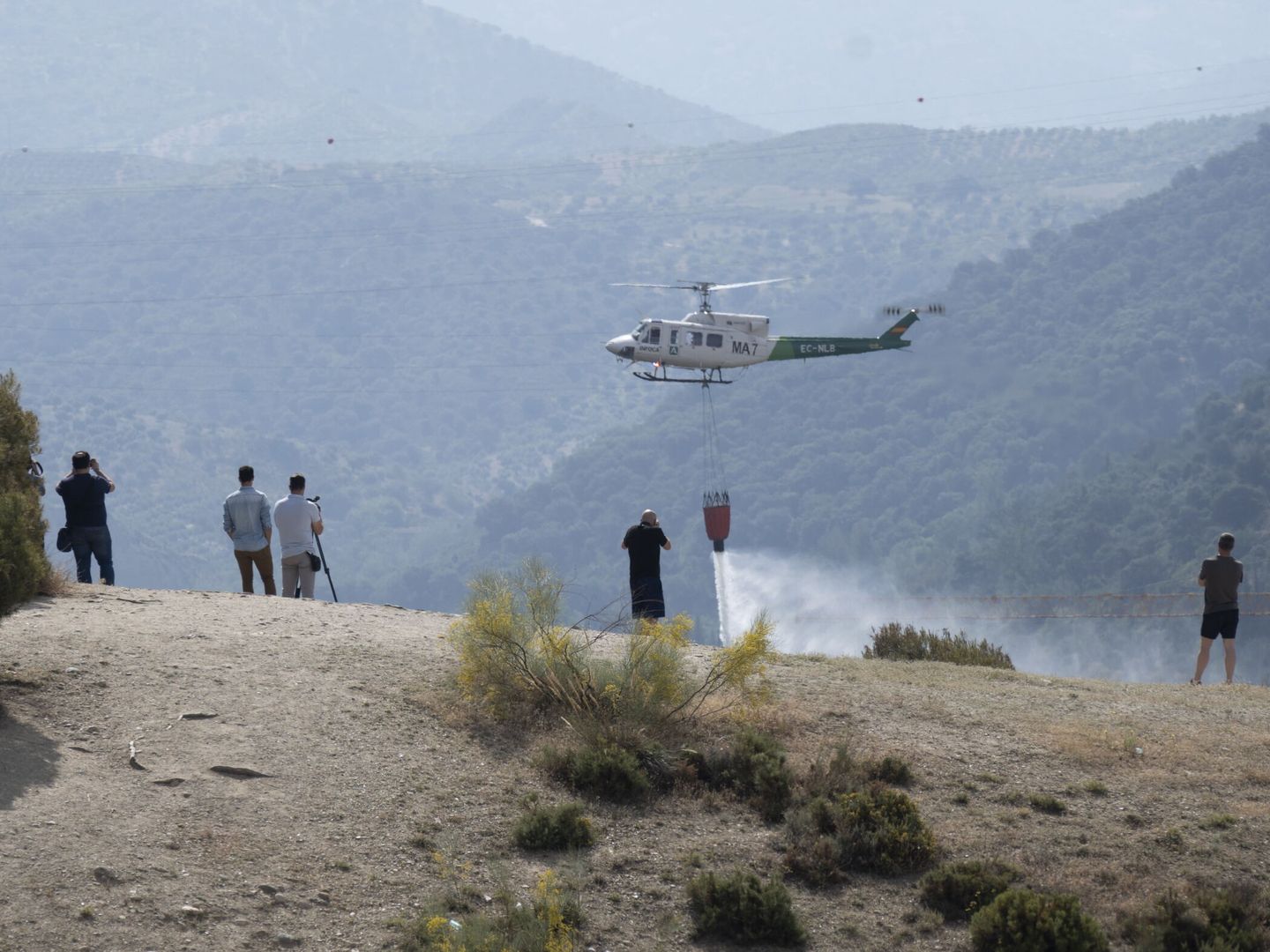 Uno de los dos helicópteros que ha trabajado en la extinción del incendio. (EFE/Miguel Ángel Molina)