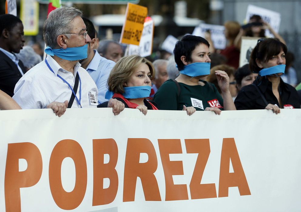 Foto: Varias personas sostienen una pancarta durante la manifestación contra la pobreza el pasado mes de octubre en Madrid (Efe)