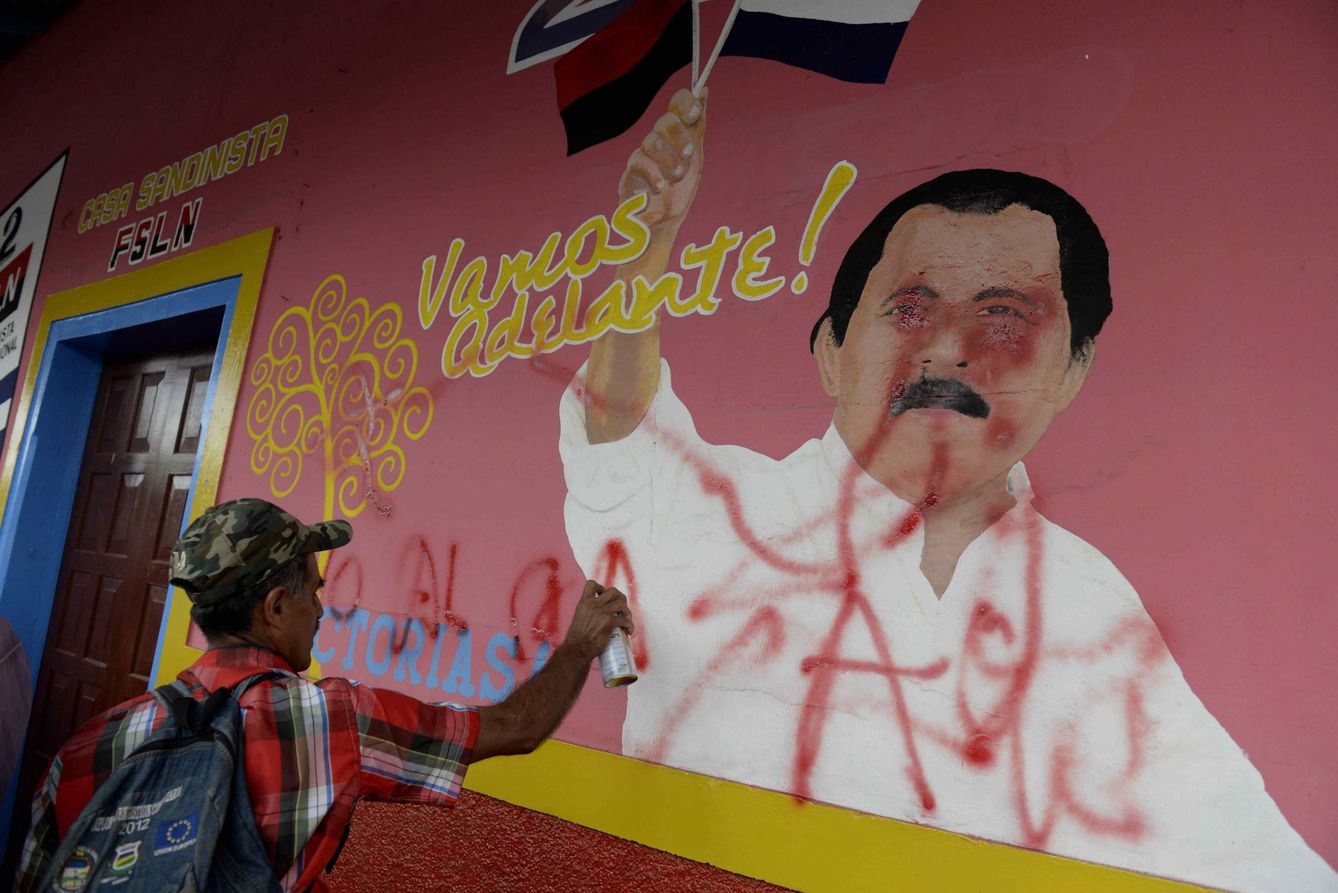 Un campesino pinta una consigna sobre la figura del presidente de Nicaragua, Daniel Ortega, durante una protesta contra el canal en 2015 (EFE)