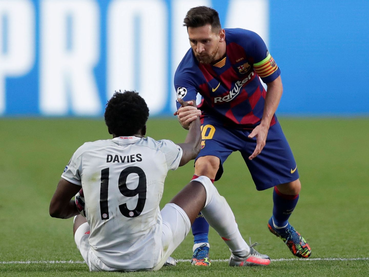 Leo Messi ayuda a levantarse a Alphonso Davies tras un lance del juego. (Reuters)