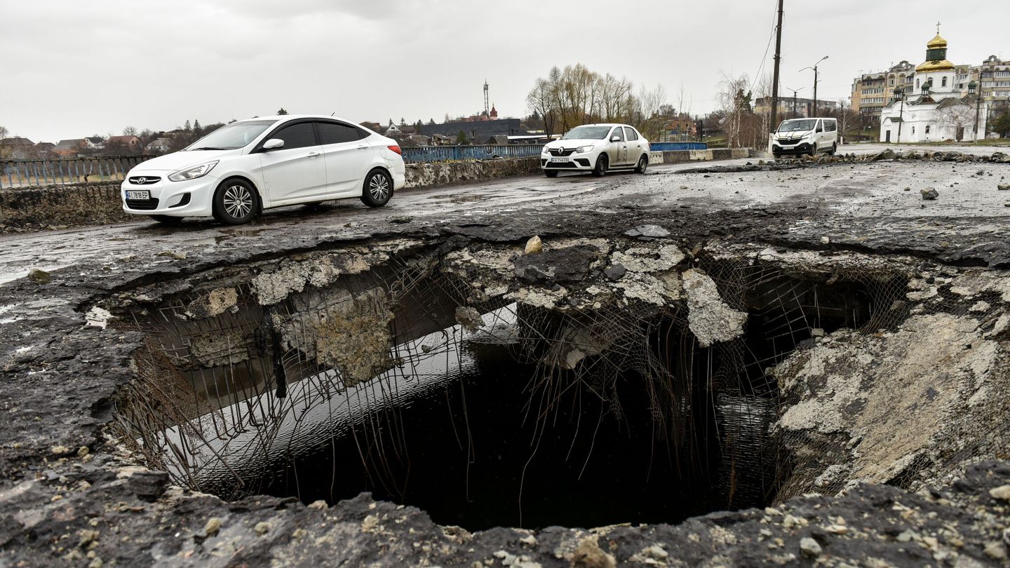 Un cráter de un proyectil en un puente dañado en la ciudad recuperada de Makariv. (EFE / Oleg Petrasyuk)