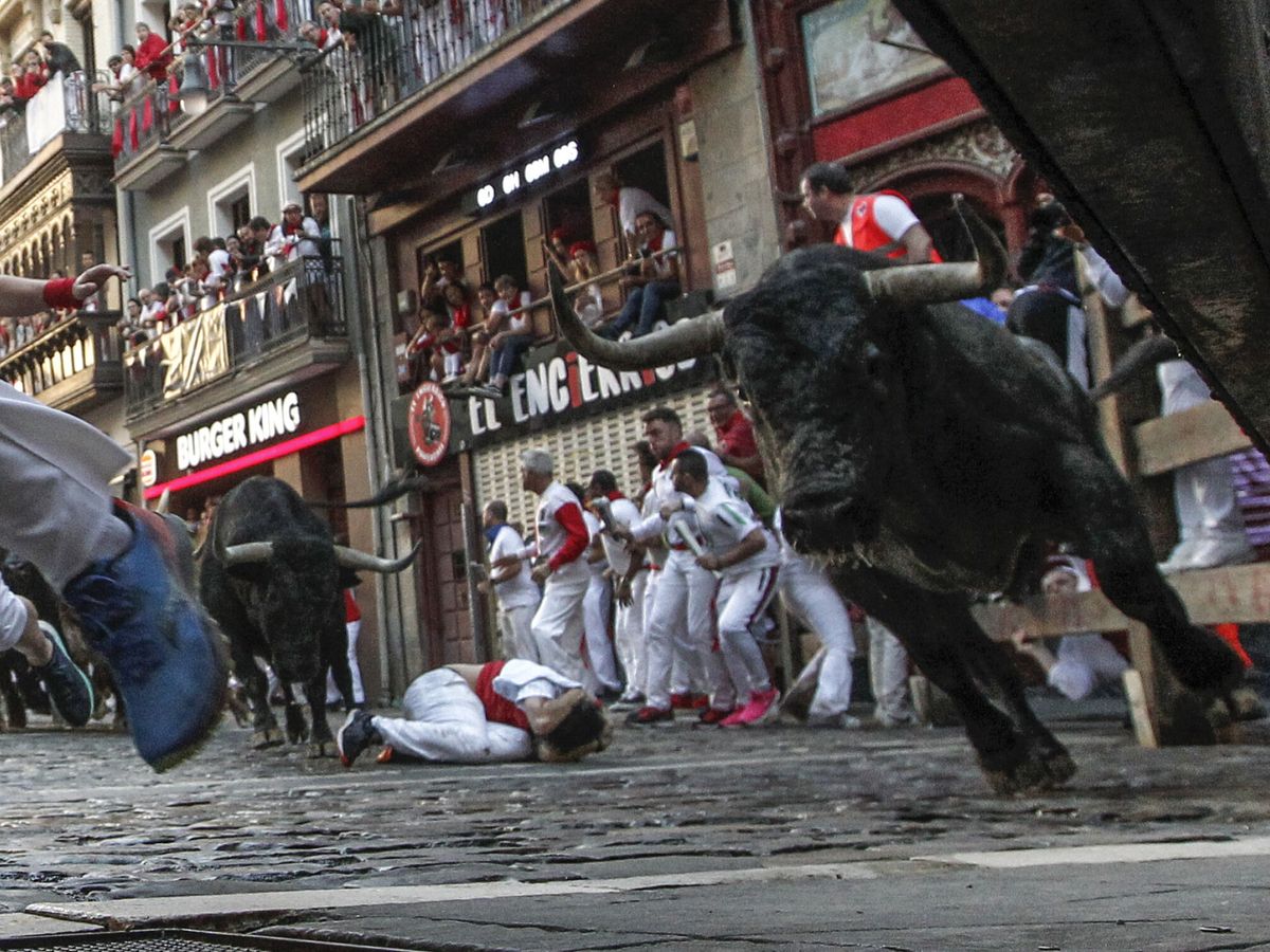 Foto: Los mozos corren delante de los toros en el tercer encierro de San Fermín 2022. (EFE/Jesús Diges)