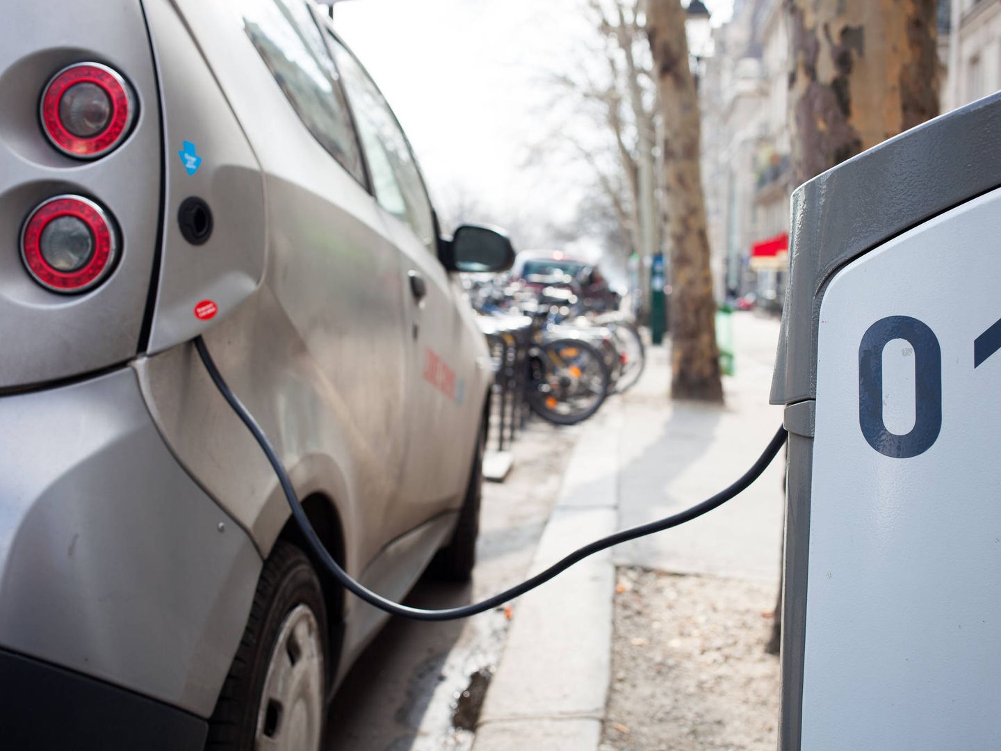 Un coche eléctrico carga sus baterías en un punto callejero. (EFE)