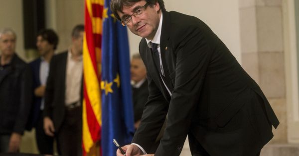 Foto: El presidente de la Generalitat, Carles Puigdemont, firma el documento sobre la Independencia después de comparecer ante el pleno del Parlament para trasladar los resultados de la jornada del 1-O. (EFE) 