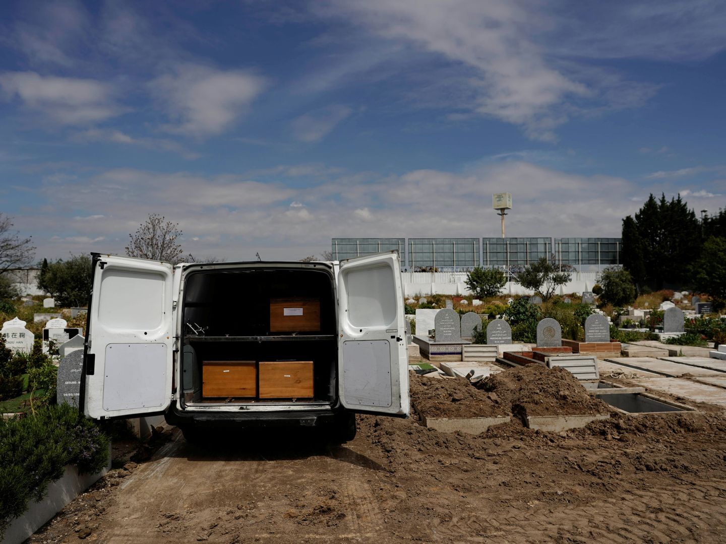 Una furgoneta con tres féretros de víctimas de coronavirus en el cementerio de Griñón. (Reuters)