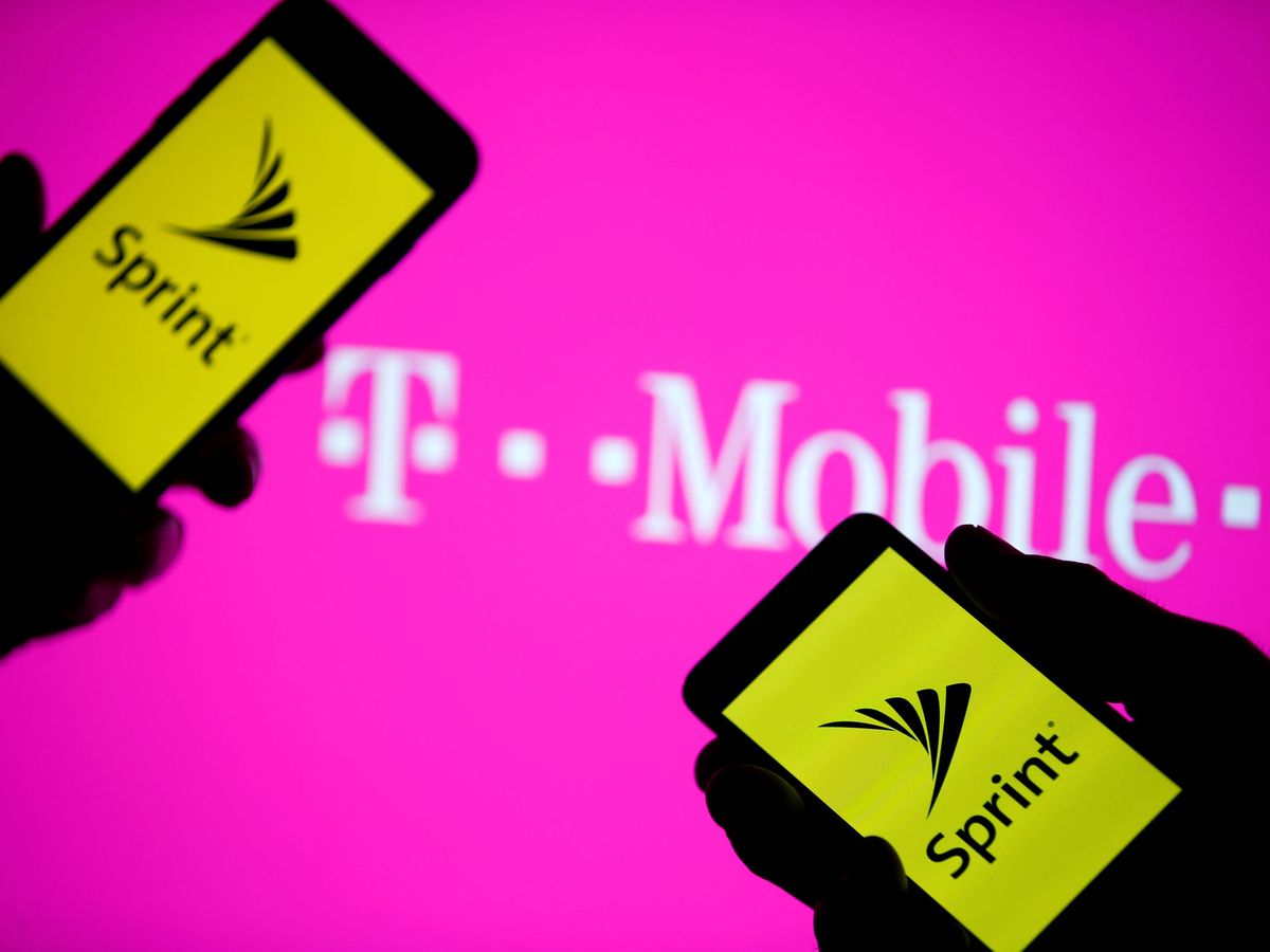 Foto: Dos 'smartphones' con el logo de Sprint frente a un cartel de T-Mobile. (Reuters)