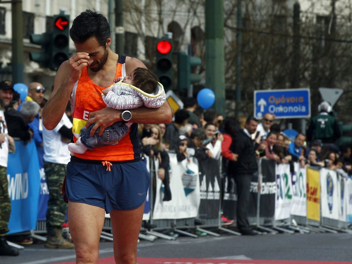 Foto: Un atleta cruza la meta con su bebé en brazos tras participar en el 6º Medio Maratón de Atenas de 2017. (EFE)