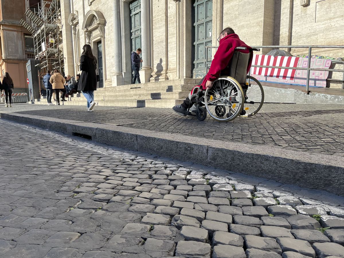 Foto: Un hombre va en silla de ruedas por Roma. (EFE/Miguel Salvatierra)