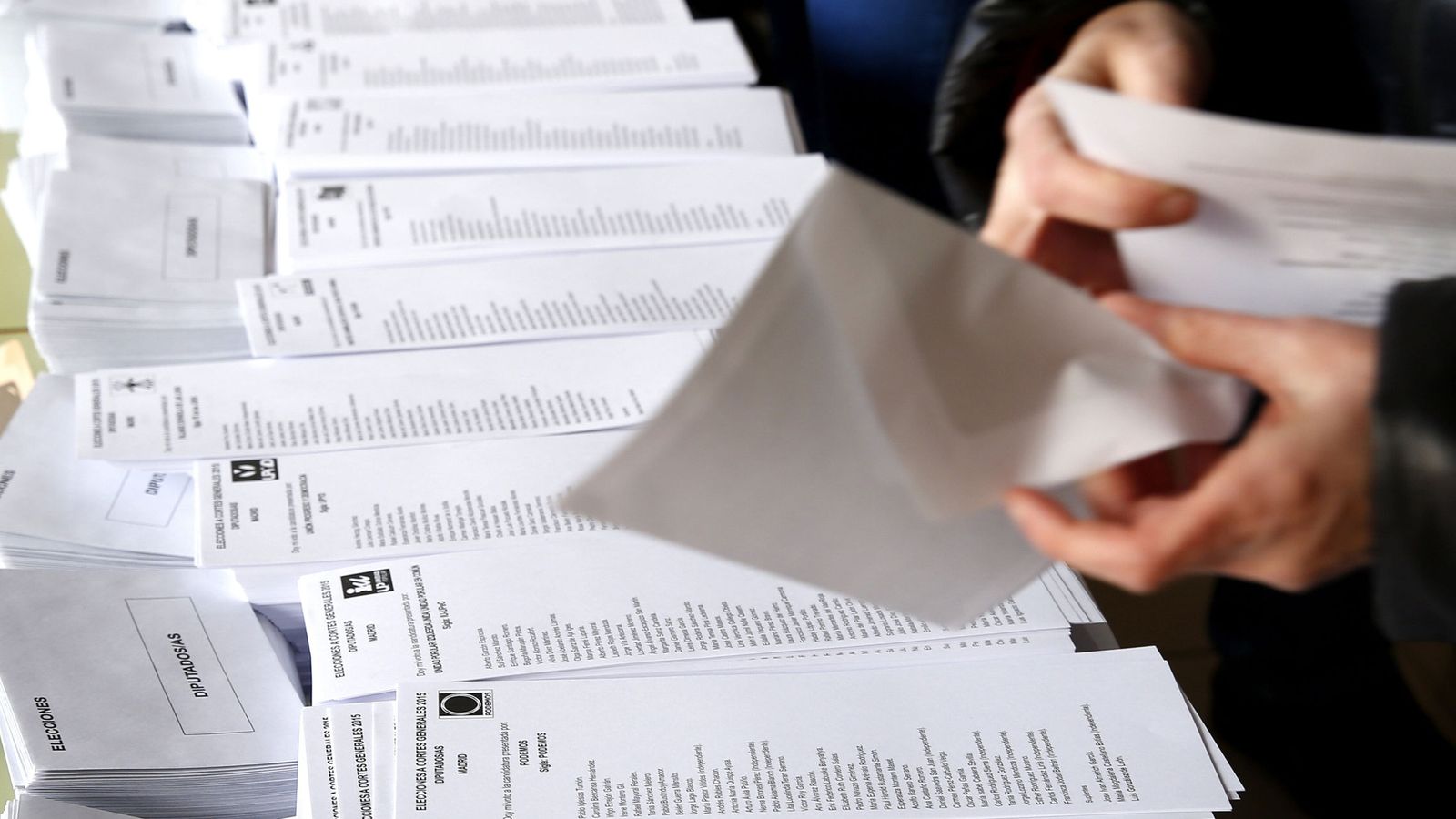 Foto: Una persona selecciona una de las papeletas al Congreso en un colegio electoral en Madrid. (EFE)