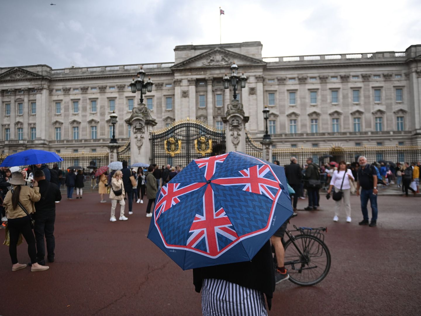 Decenas de personas bajo la lluvia frente al Palacio de Buckingham en Londres. (EFE/EPA/Neil Hall) 