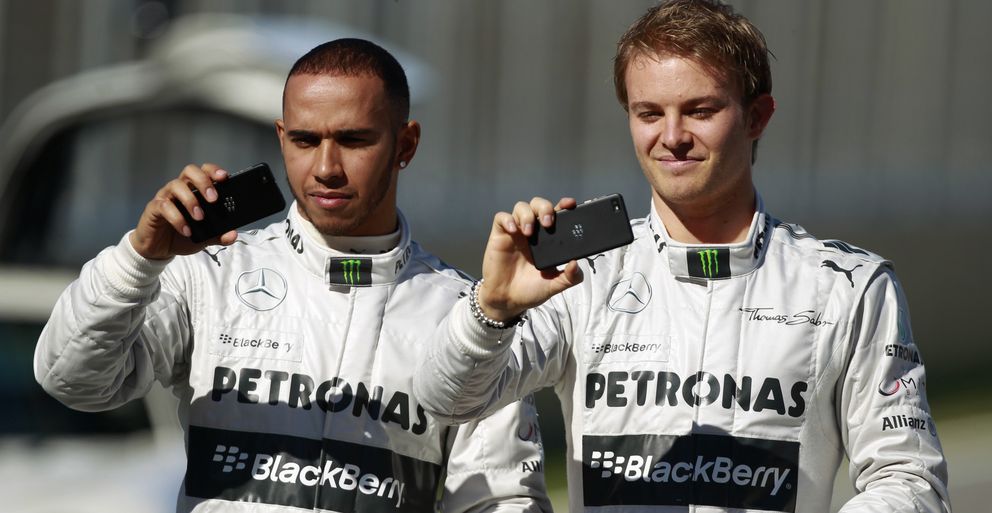 Hamilton y Rosberg usan una Blackberry en la presentación del W04 la pasada temporada. (Reuters)