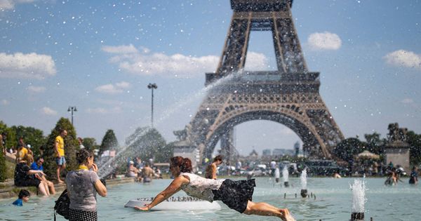 Foto: Ciudadanos se refrescan frente a la Torre Eiffel durante una ola de calor. (EFE)
