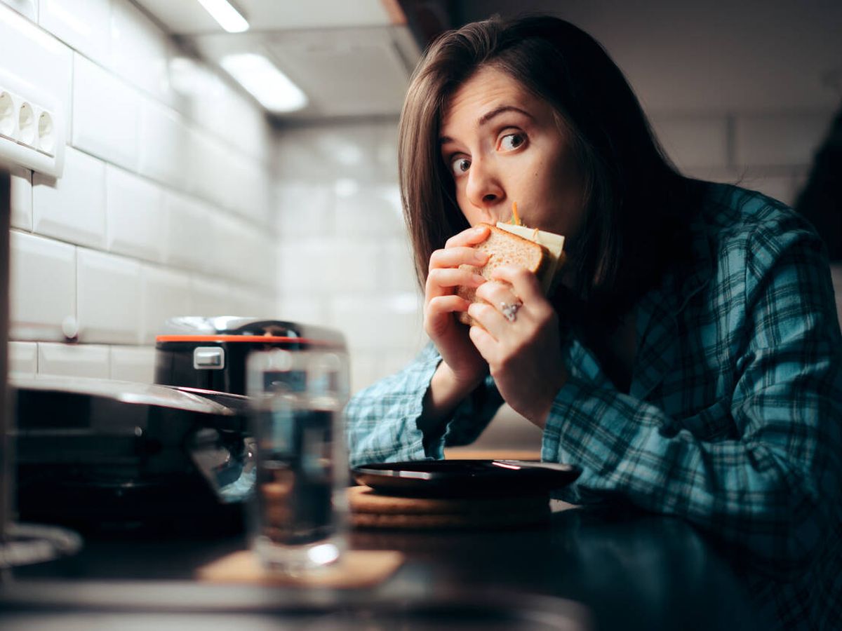 Foto: Una chica comiendo a escondidas (iStock)