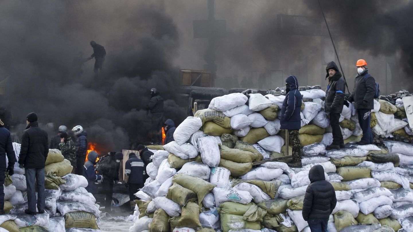 Manifestantes hacen guardia sobre nuevas barricadas en Kiev (Reuters).
