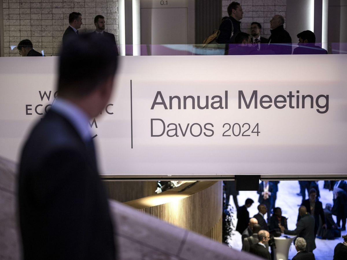 Foto: Un participante pasa por delante del logo del Foro de Davos. (EFE/EPA/Gian Ehrenzeller)