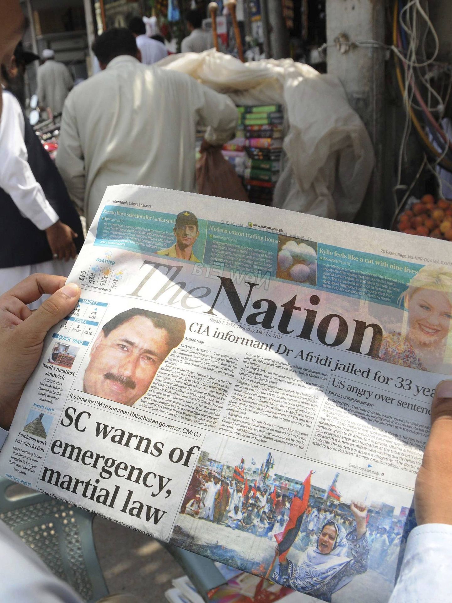Un hombre lee el periódico en el que se informa de la condena del doctor Shakil Afridi. (EFE)