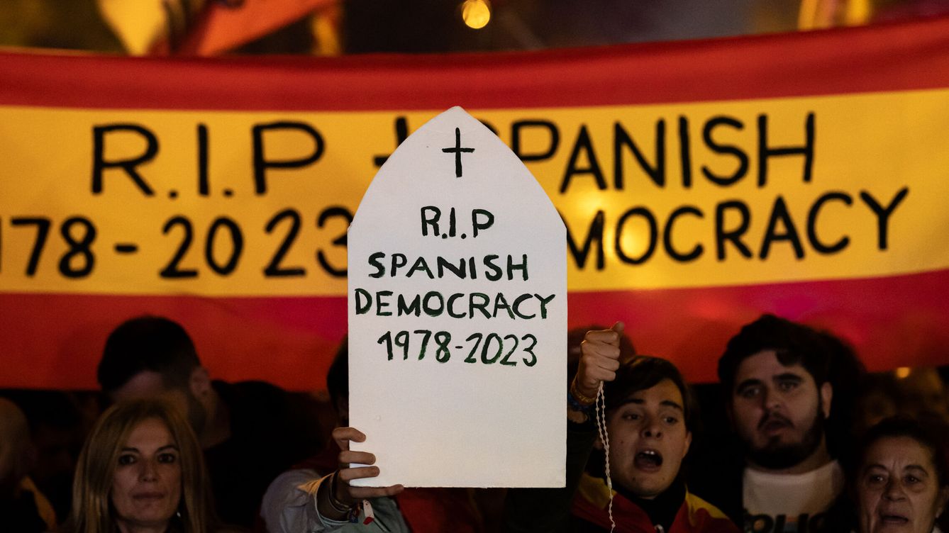 Foto: Manifestantes con pancartas, durante una manifestación contra la amnistía frente a la sede del PSOE en Ferraz. (Europa Press/Diego Radamés)