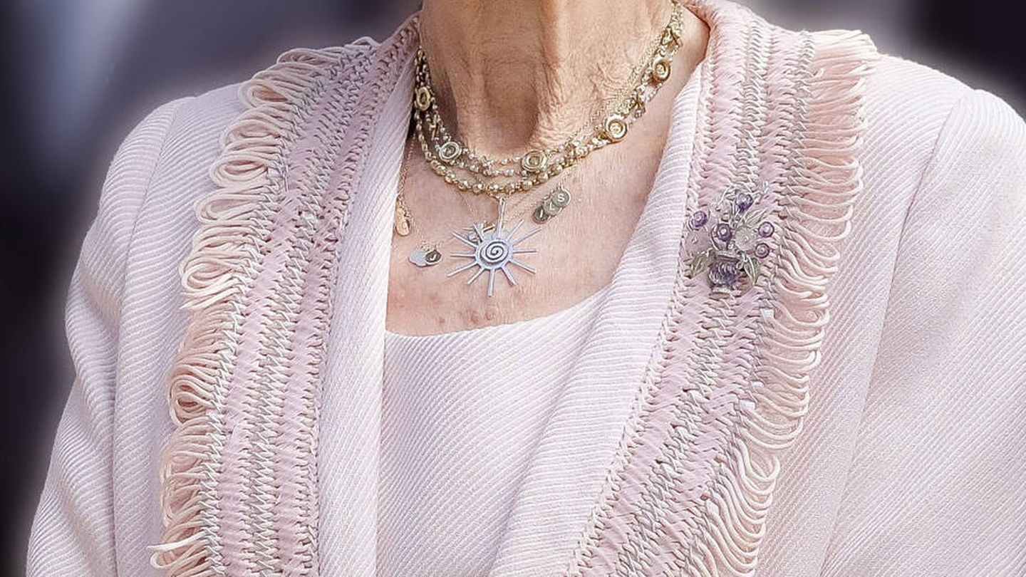 Detalle del colgante de la reina Sofía, con las iniciales de sus hijos y nietos en pequeñas medallas. (EFE)