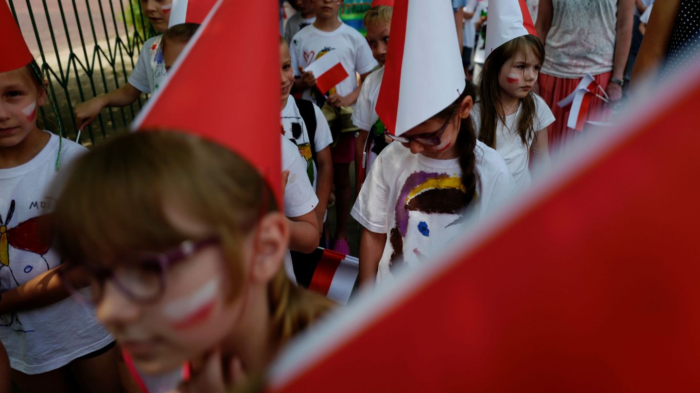Alumnos con capirotes, banderas y la cara pintada con los colores de Polonia (REUTERS)