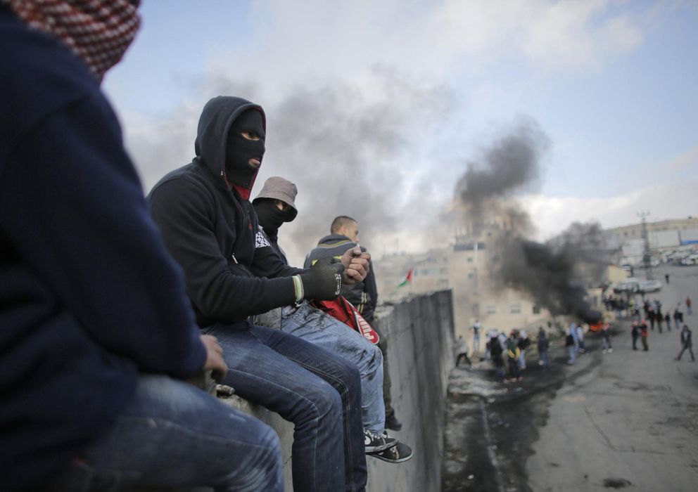 Foto: Palestinos sobre una sección del muro que separa Cisjordania de Jerusalén el 17 de noviembre (Reuters).