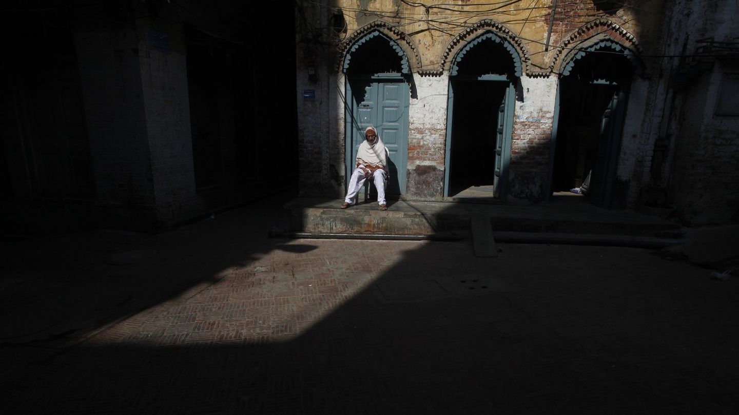 Un hombre, sentado en su casa en la zona vieja de Lahore. (EFE)