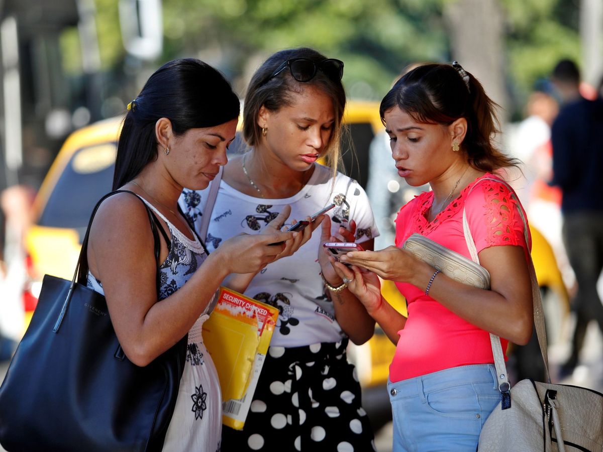Foto: Unas jóvenes consultan sus teléfonos móviles. Foto: EFE Yander Zamora