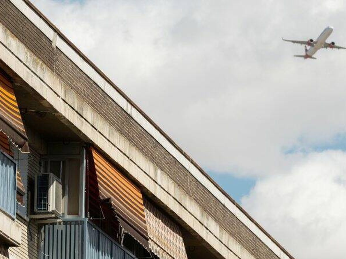 Foto: Un avión sobrevuela un edificio en el madrileño barrio de Barajas. (EFE)