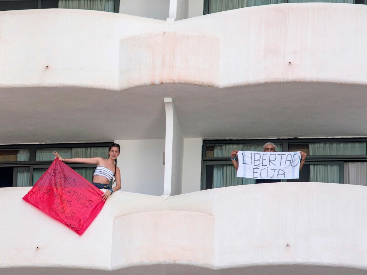 Foto: Dos jóvenes que permanecen en aislamiento en el hotel Palma Bellver de Palma. (EFE)