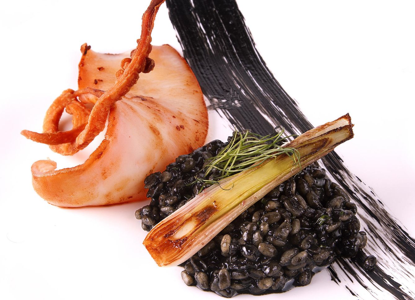Calamar a la brasa en su jugo con risotto de trigo negro y cebolletas tiernas