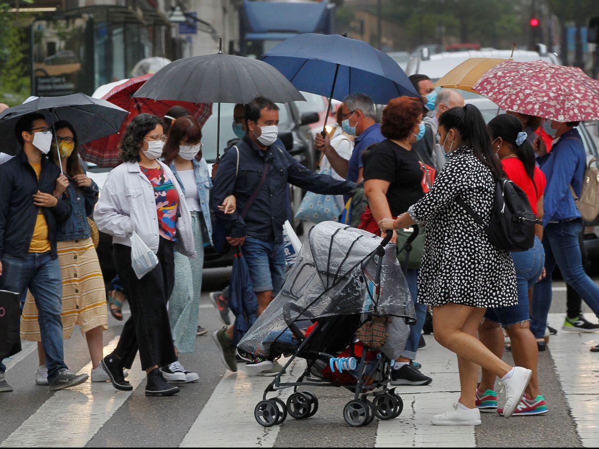 Foto: Viandantes con paraguas en una calle de Oviedo. (EFE)