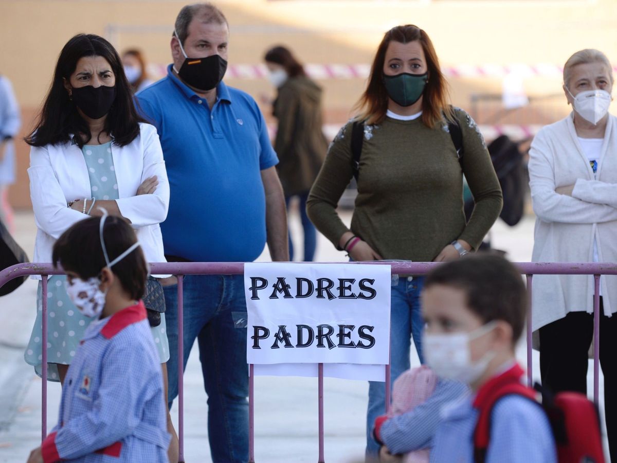 Foto: Un grupo de padres observa la entrada de sus hijos en un colegio de Valladolid. (EFE)