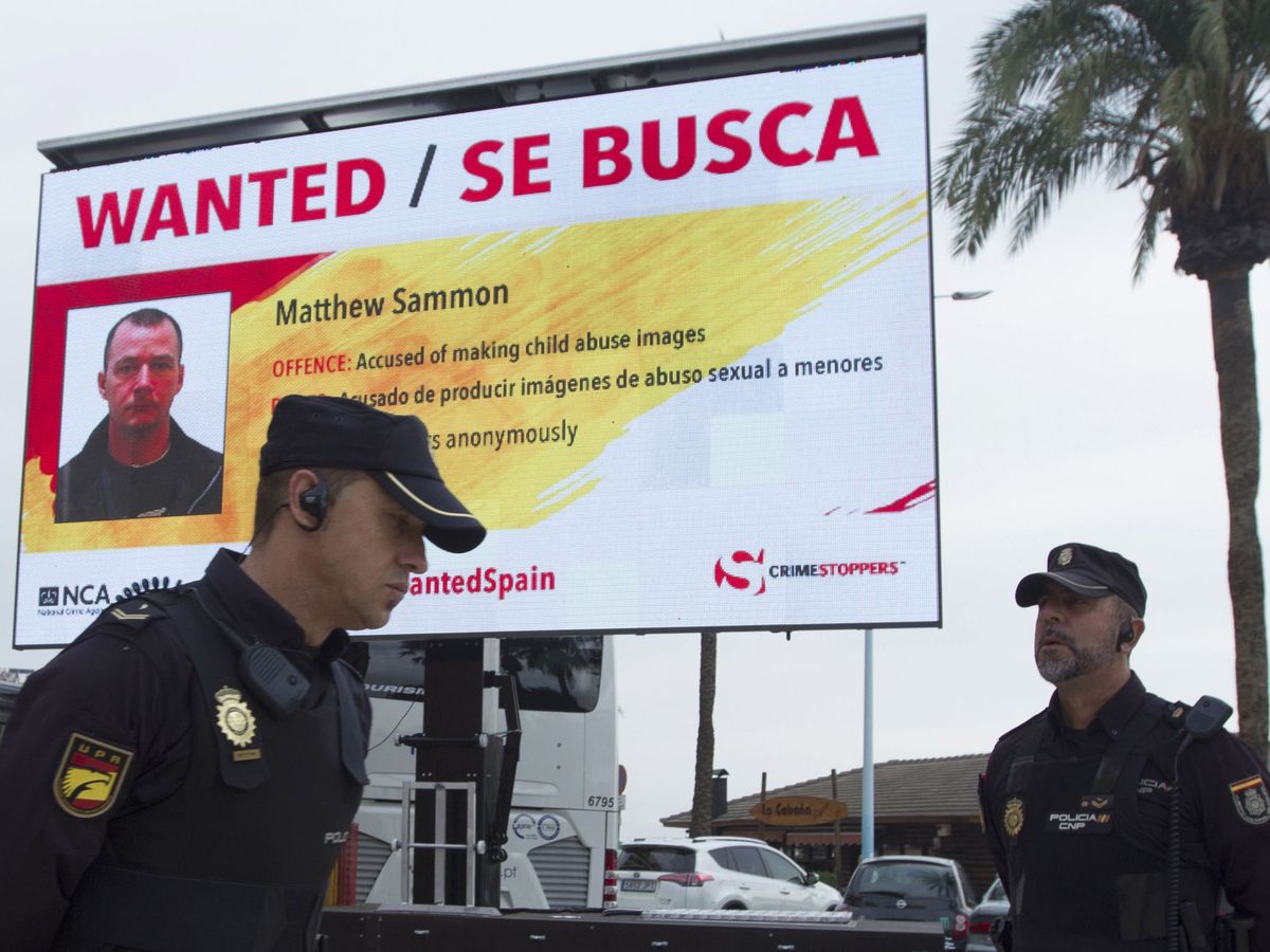 Foto: Agentes de policía delante de un cartel de una campaña de búsqueda de fugitivos británicos en España, en una imagen de archivo. (EFE/Jorge Zapata)