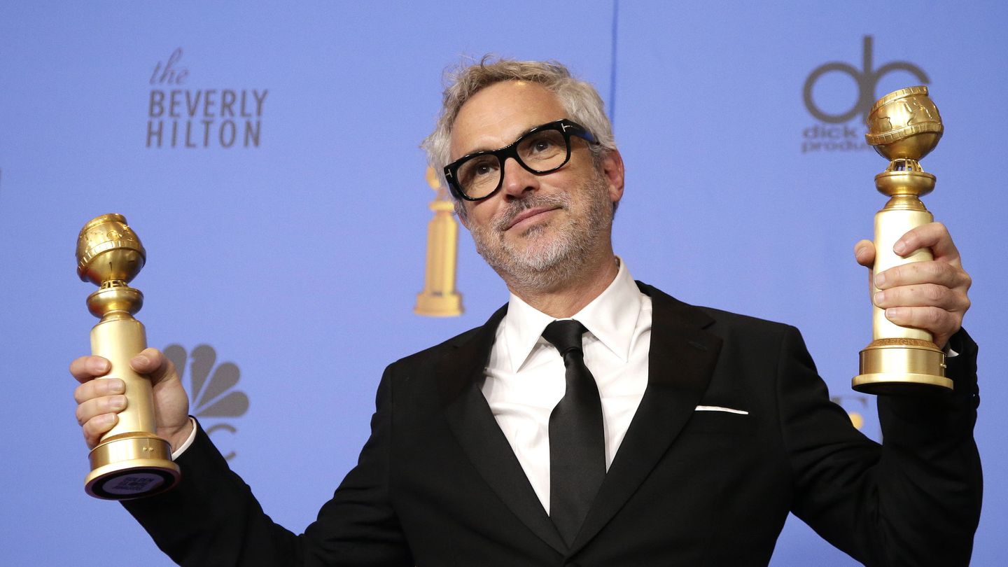 Alfonso Cuarón sujeta sus dos globos de oro. (Efe)