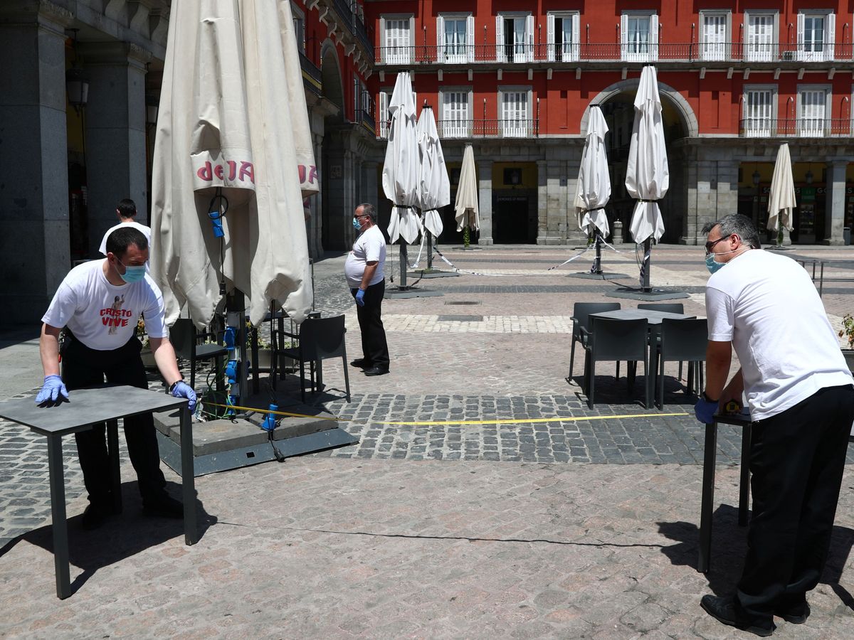 Foto: Trabajadores preparan las terrazas de la plaza Mayor de Madrid, este 24 de mayo. (Reuters)