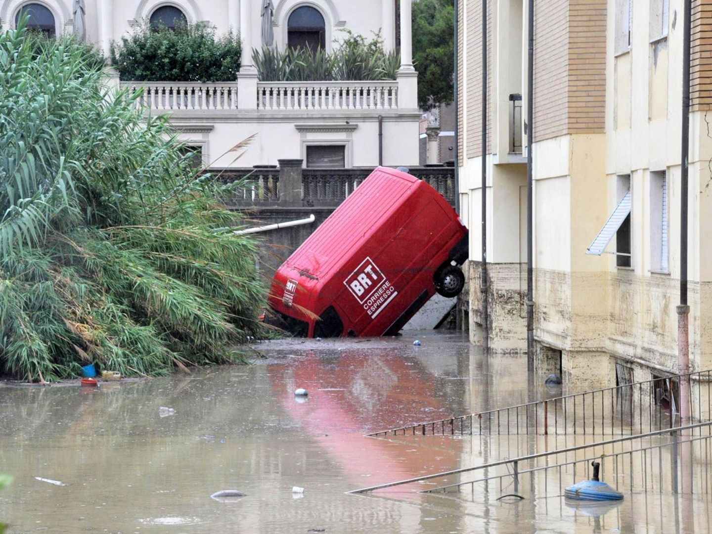 Vista de una camioneta semihundida en una calle inundada en Livorno, Italia. (EFE)