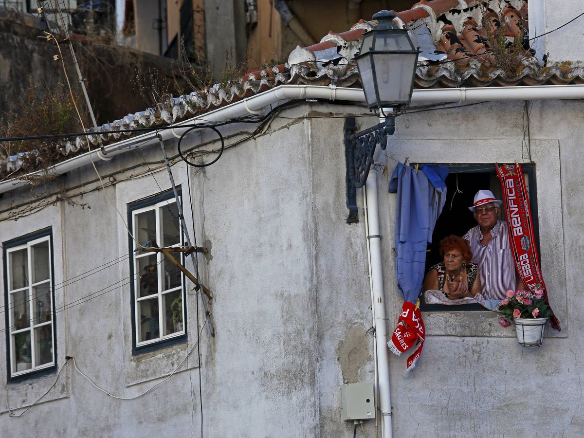 Foto: Unos ancianos en una ventana en Lisboa. (Reuters)
