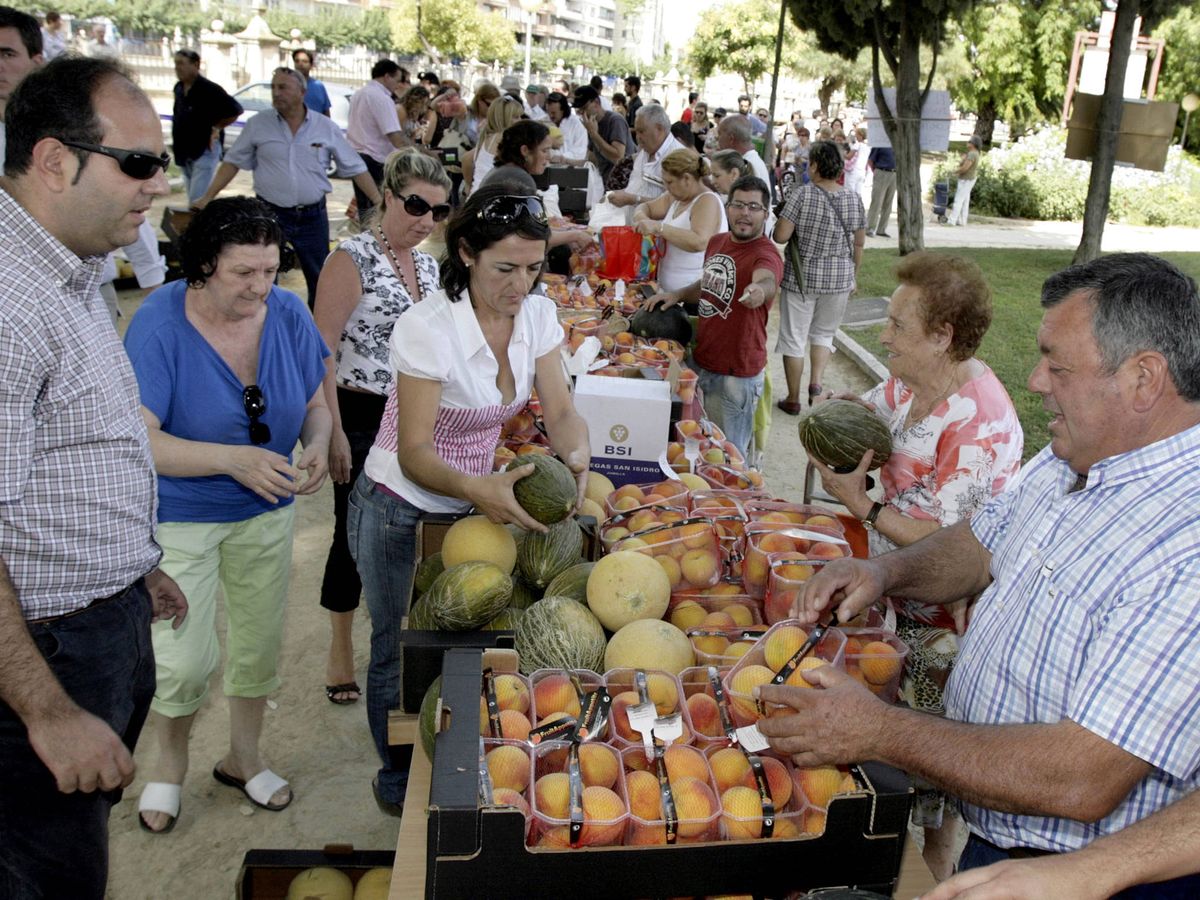 Foto: Agricultores murcianos entregando a los ciudadanos fruta en un mercado solidario. (EFE)