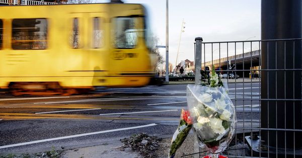 Foto: Un tranvía pasa junto a los ramos de flores depositados en el lugar del tiroteo. (EFE) 