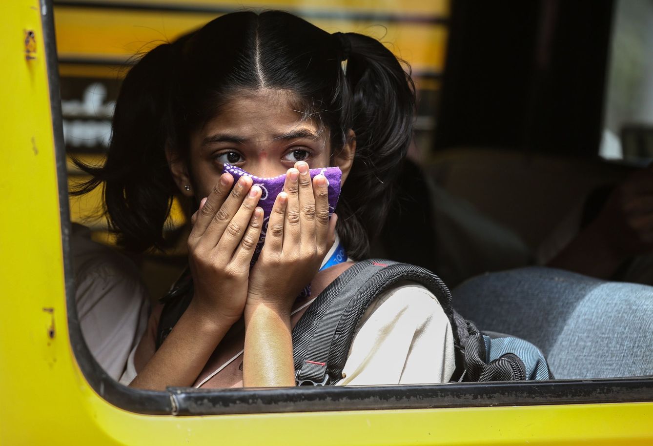 Una adolescente se coloca un pañuelo en la cara en el transporte público. (EFE)