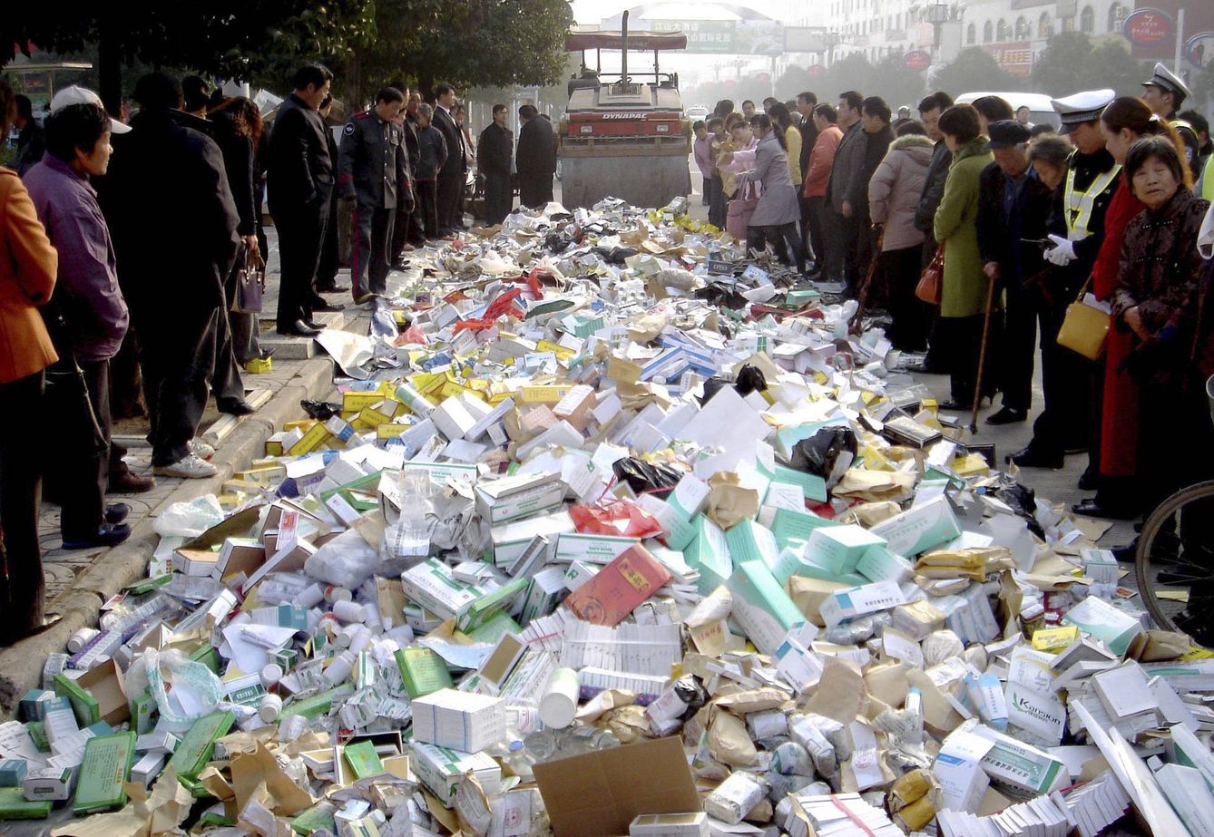 Vecinos de Suqian observan la destrucción de medicamentos falsificados con una apisonadora, en diciembre de 2006. (Reuters)