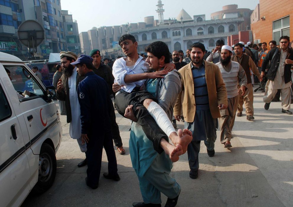 Foto: Un hombre traslada a un estudiante herido en el ataque talibán a una escuela en Peshawar (Reuters).