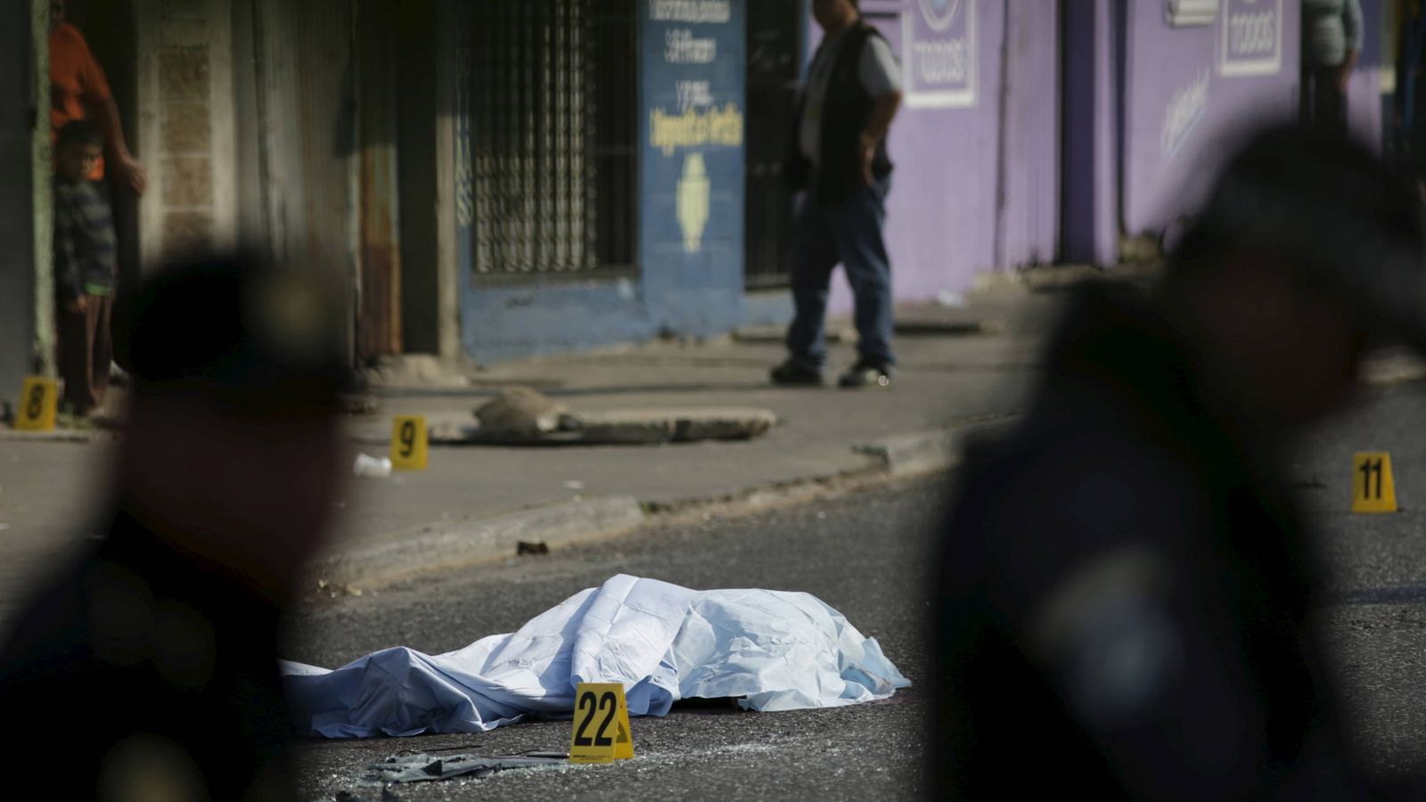 Foto: Agentes de policía junto al cadáver de una víctima de las maras, en Ciudad de Guatemala. (Reuters)