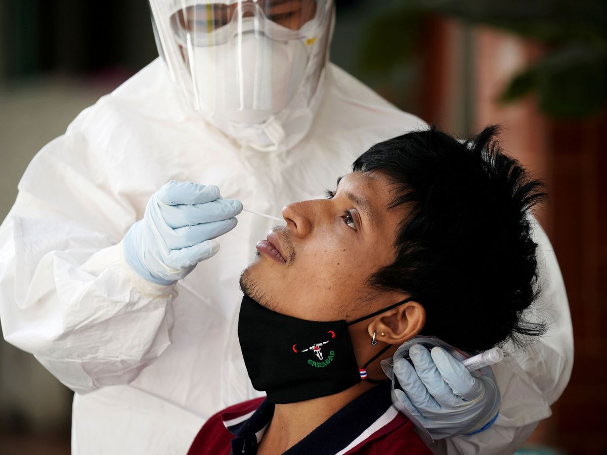 Foto: Un sanitario realiza un test a un migrante en Tailandia. (Reuters)